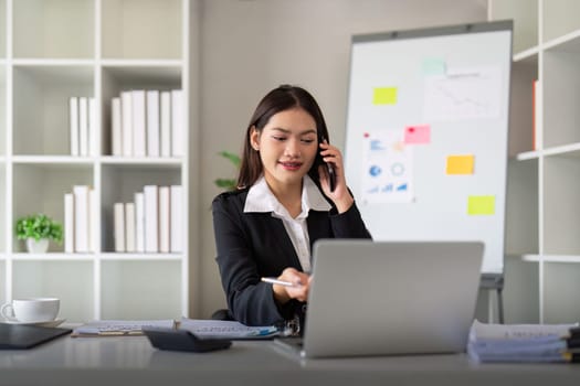 Happy confident businesswoman talking on the phone. Smiling female business person talking work using talking on the phone at office sitting at desk.