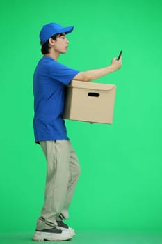The delivery guy, on a green background, full-length, with a box and a phone.