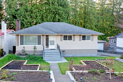 Residential family house with gardent patches in wooden beds on the front yard