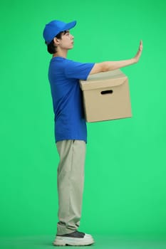 The delivery guy, on a green background, full-length, with a box, shows a stop sign.