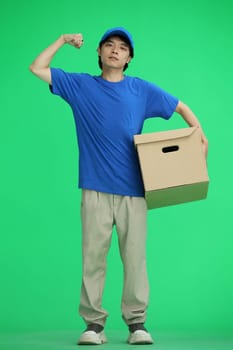 The delivery guy, on a green background, full-length, with a box, shows strength.