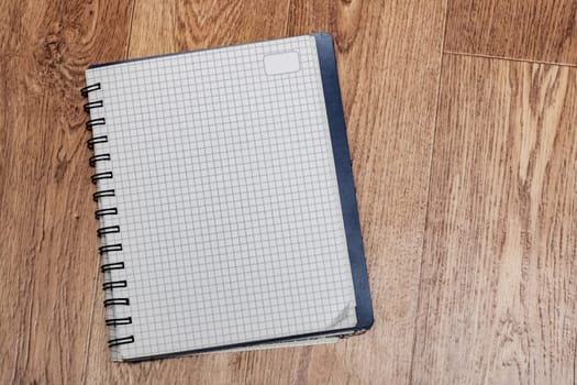 Blank sheet of notebook on a wooden table, copy space