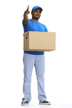 A male deliveryman with a box, on a white background, in full height, points forward.