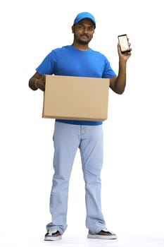 A male deliveryman with a box, on a white background, full-length, with a phone.