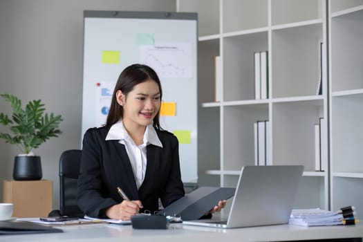 Business documents, business auditor Asian woman is reviewing legal documents, preparing documents or reports for analysis tax accountant documents agreement contract information in office at work.