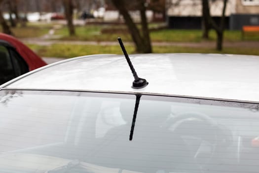 Roof of a white car with raindrops close up