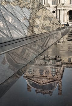 France, Paris - Jan 03, 2024 - View of The historical palace building in water reflection effect by after raining at the front of Louvre pyramid in the Louvre museum in Paris. is one of the world's largest museums in Paris, Space for text, Selective focus.