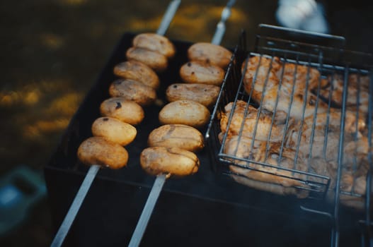 Potato skewers on burning coals on outdoor grill. High quality photo