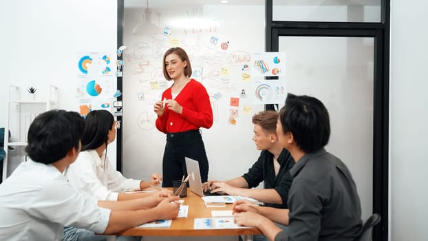 Young beautiful leader presents marketing strategy while expert investor and project manager listening and lecturing to analyze business performance at start up business meeting. Immaculate.