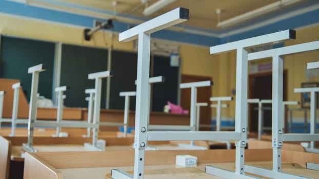 The concept of graduating from high school. Upside-down chairs in an empty classroom at the school