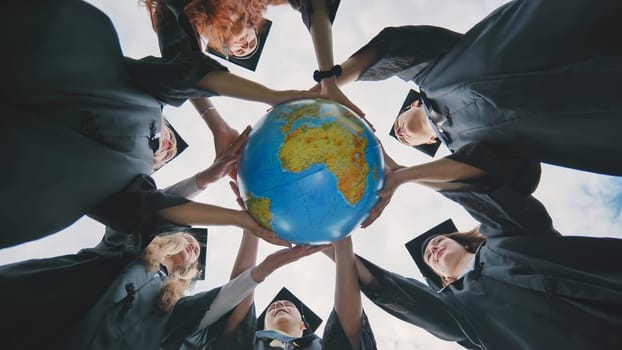 Graduating students twirl a geographic globe of the world in their hands