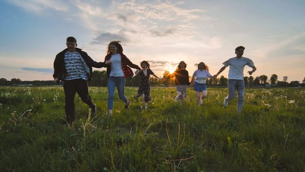 Merry friends run off into the sunset holding hands