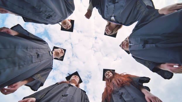 College students stand in a circle wearing black robes