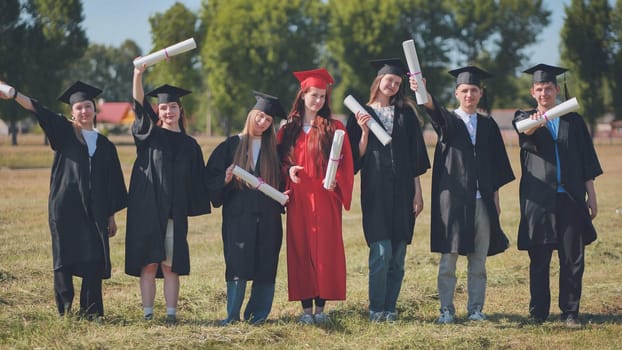 group of multiracial graduates holding diploma