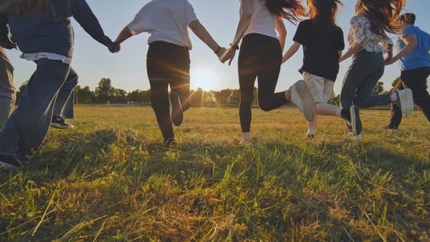 Young boys running at sunset across the field holding hands