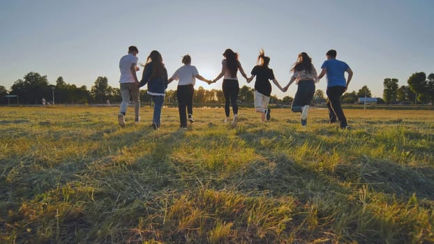 Children running on meadow at sunset