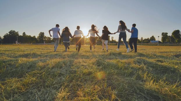 Young boys running at sunset across the field holding hands