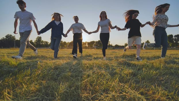 Young boys running at sunset across the field holding hands