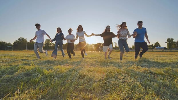 Young boys running at sunset across the field holding hands