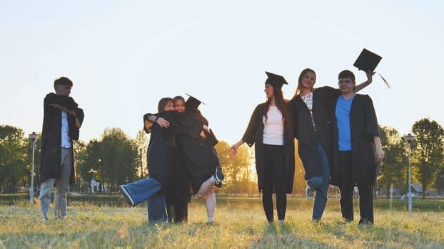 Student alumni waving at sunset