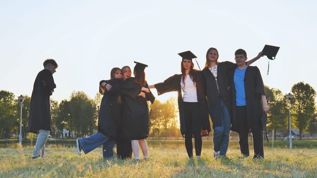 College alumni friends pose in the evening meadow