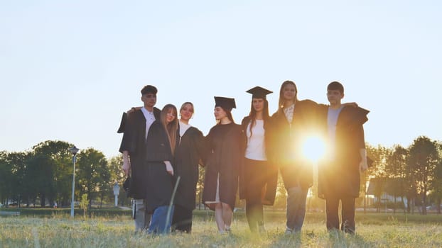 Student alumni waving at sunset