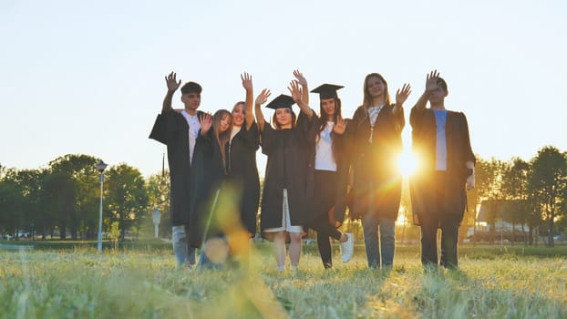 College alumni friends pose in the evening meadow