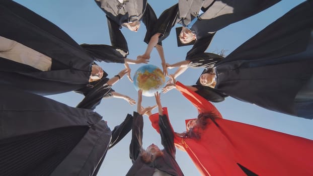 College alumni students toss a globe of the world into the sky