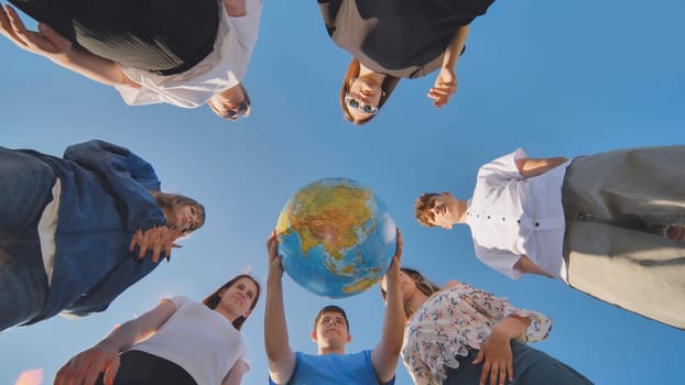 The concept of keeping the world safe. Friends holding a geographical globe in their hands