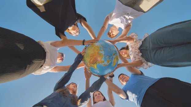 The concept of keeping the world safe. Friends holding a geographical globe in their hands