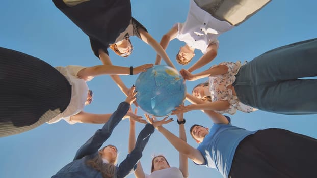 Friends holding a geographical globe in their hands. The concept of keeping the world safe