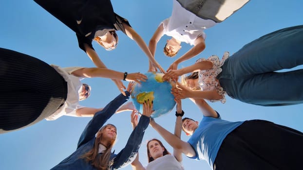 The concept of keeping the world safe. Friends holding a geographical globe in their hands