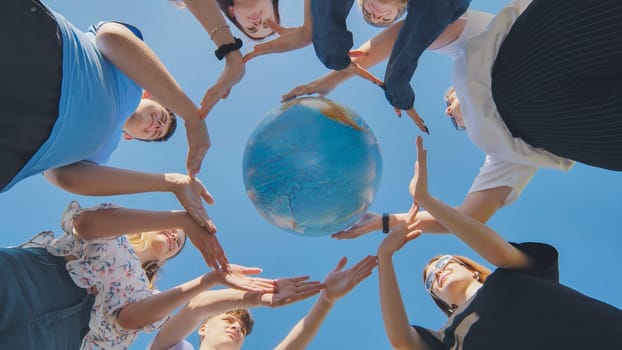 Students make a circle around the globe of the world. The concept of world peace