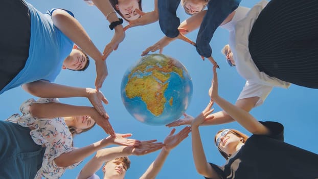 Students make a circle around the globe of the world. The concept of world peace