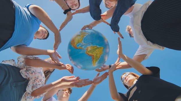 Young friends surround the globe of the world with their palms. The concept of preserving world peace