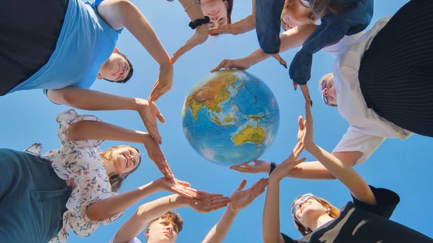 Students make a circle around the globe of the world. The concept of world peace