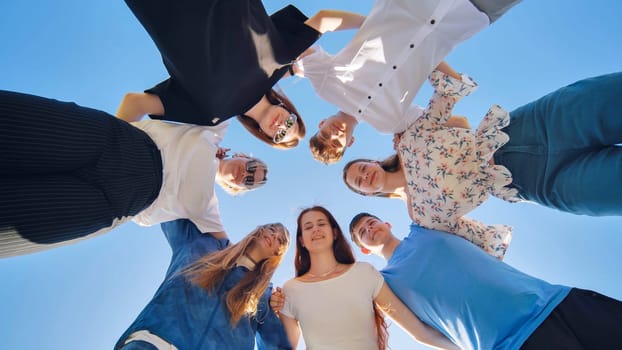 Friends put their heads together in a circle on a summer afternoon