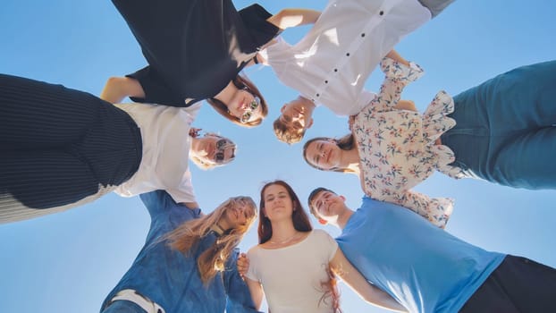 Friends put their heads together in a circle on a summer afternoon