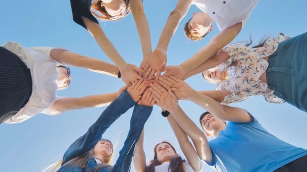 Friends putting their hands together in a sign of unity and teamwork. Just the hands