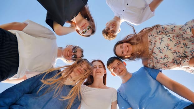 Friends put their heads together in a circle on a summer afternoon