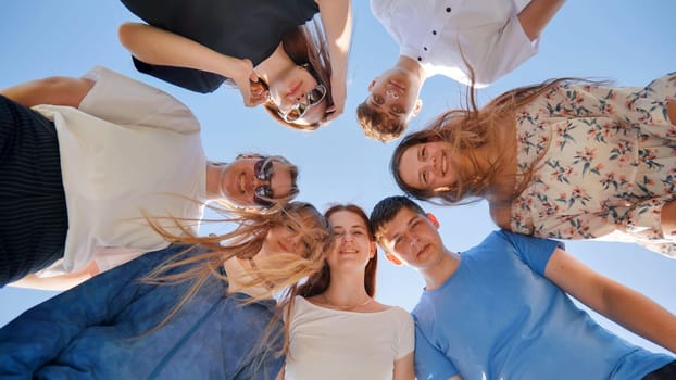 Friends put their heads together in a circle on a summer afternoon