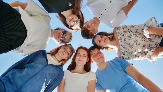 Friends put their heads together in a circle on a summer afternoon