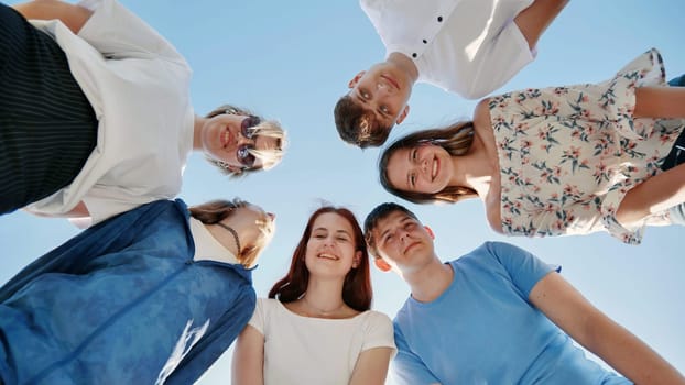 Friends put their heads together in a circle on a summer afternoon