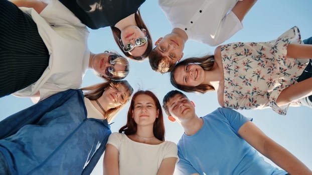 Friends put their heads together in a circle on a summer afternoon