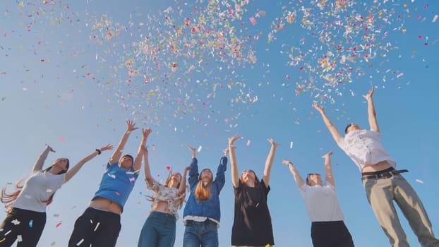 Friends toss colorful paper confetti from their hands