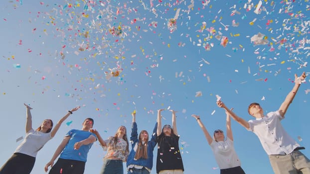 Friends toss colorful paper confetti from their hands