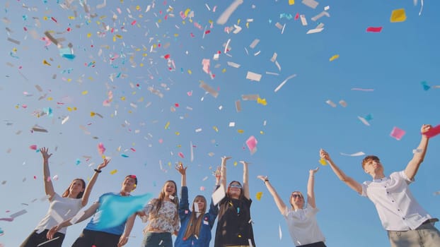 Friends toss colorful paper confetti from their hands