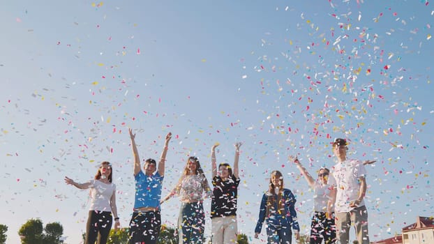 Friends toss colorful paper confetti from their hands