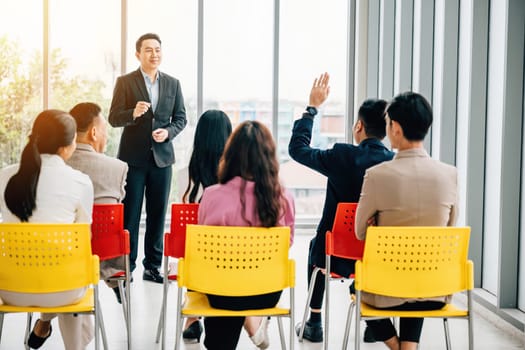In a conference, hands are raised for questions, symbolizing audience participation and interactive learning. A diverse group collaborates at a workshop or seminar, promoting teamwork and discussion.