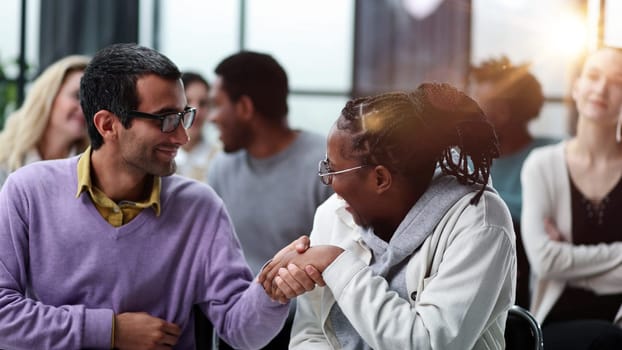black woman communicates with a man in glasses at a seminar in a conference room